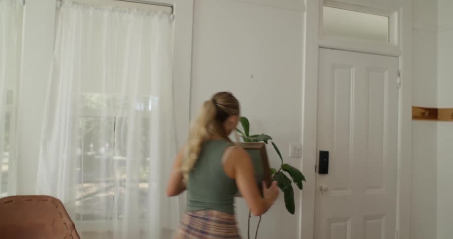 Woman taking a painting out of a box and putting it on the wall