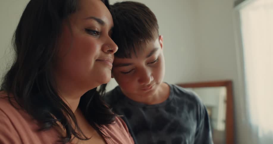 Mother and son with their heads touching each other