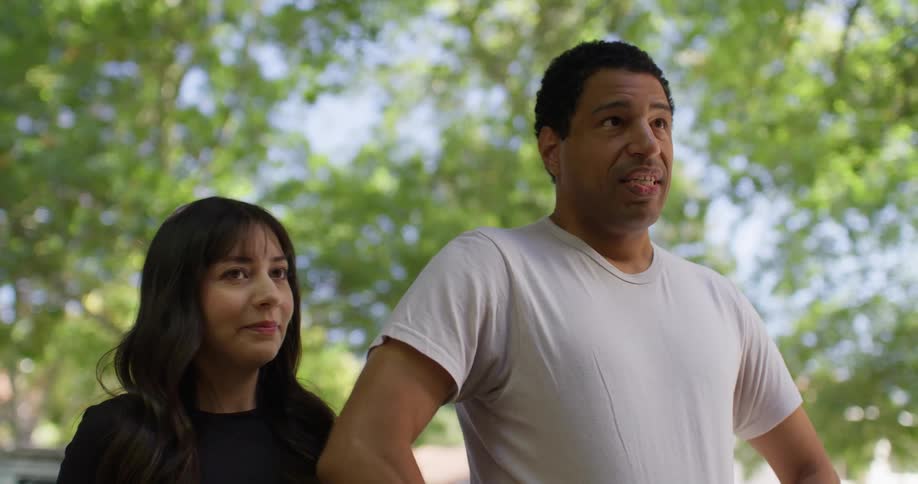 Man next to a woman taking a deep breath and patting her on the back