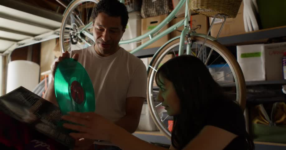 A man and woman examine a record in the garage