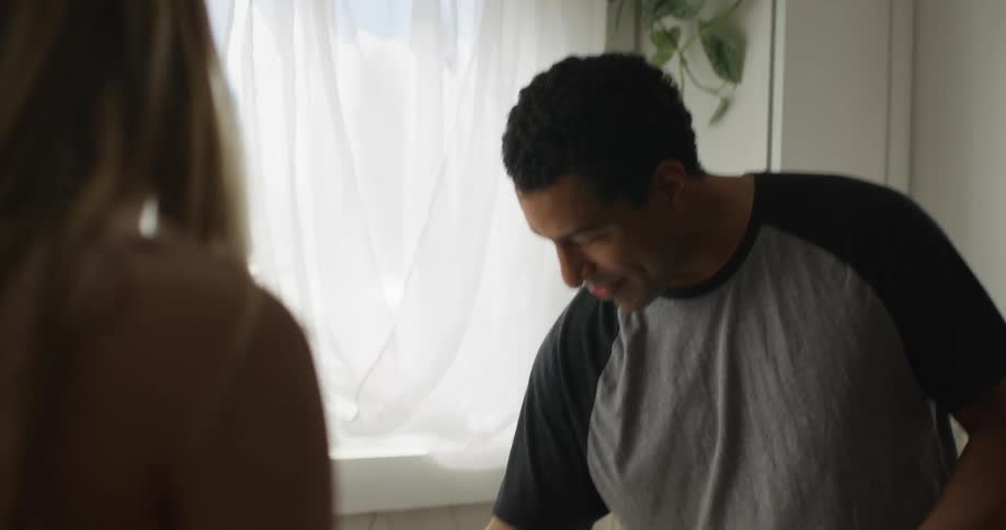 Man and woman talking at the kitchen sink
