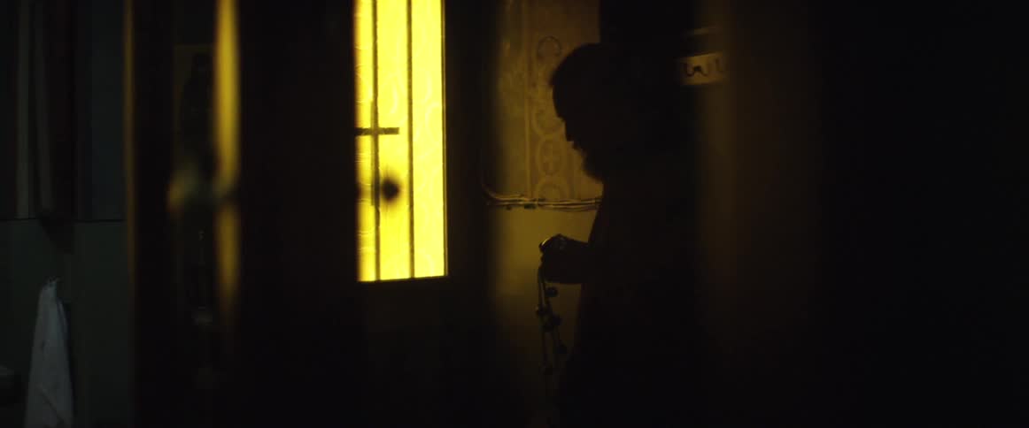Man holding something shaking it up and down in the dark