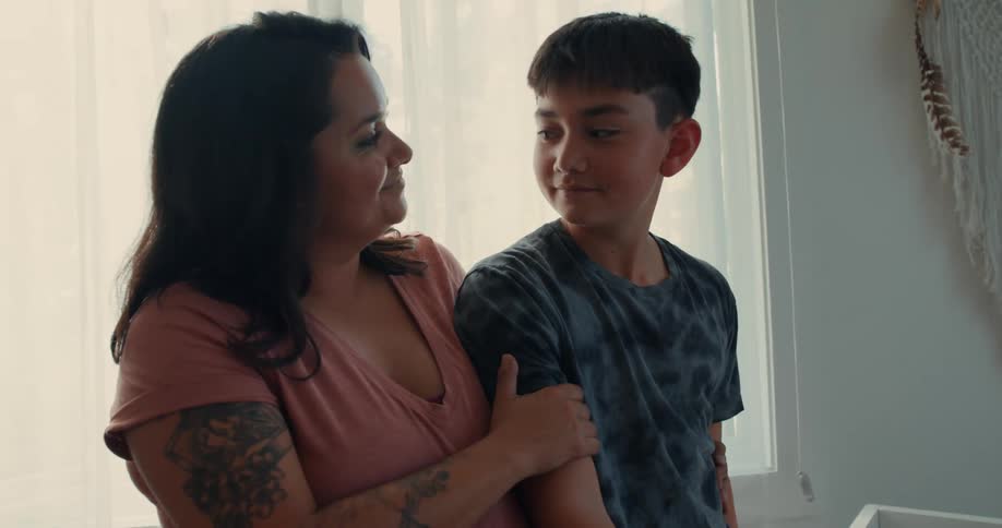 Mother giving her son a kiss on the arm