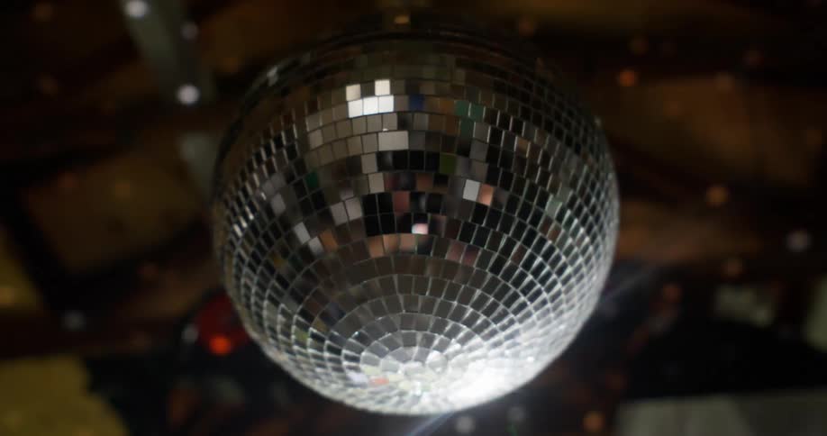 A mirrored globe that is spinning and making various sparkles reflect on the ceiling