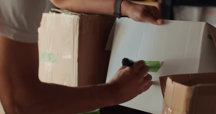 A footage of a person writing on a carton