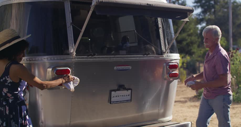 A couple clean a recreational vehicle then hug
