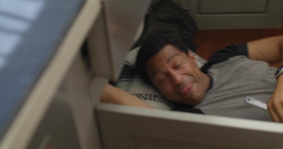 Man fixing a sink and a woman handing him a rag
