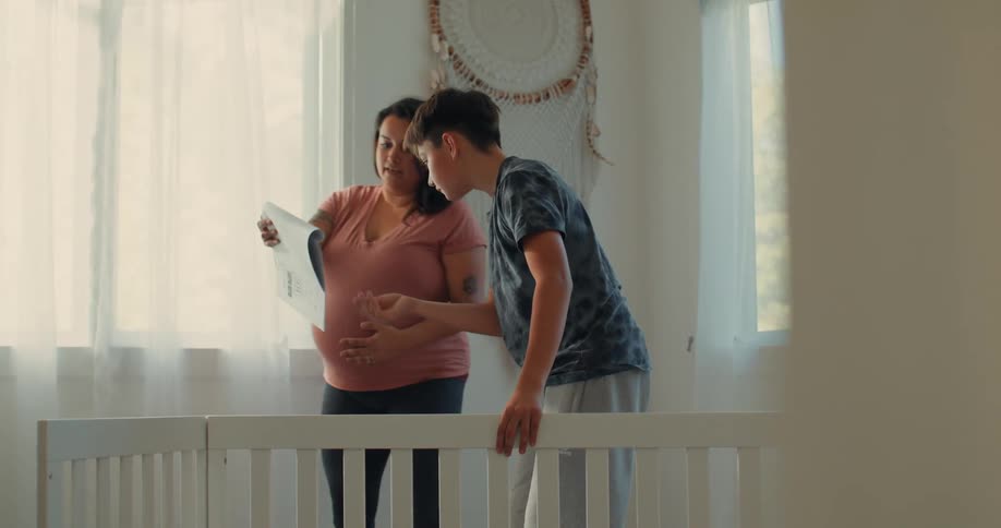 Teenager helps his pregnant mother in assembling furniture