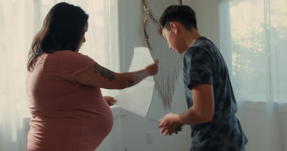 The instruction sheet guides a son and his pregnant mother as they assemble a crib