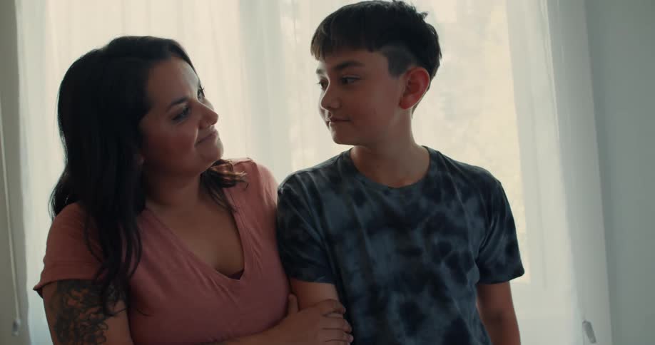 Mother in the living room stroking her sons shoulders