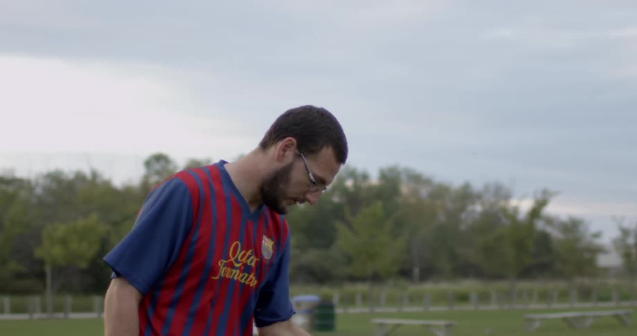 A man wipes his shoulder and bends forward