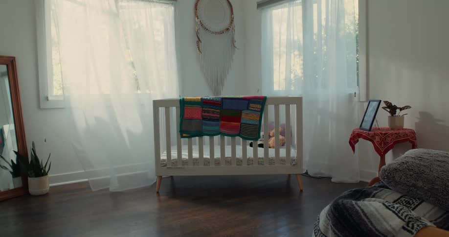Interior design of a bedroom with a crib next to a window with curtains