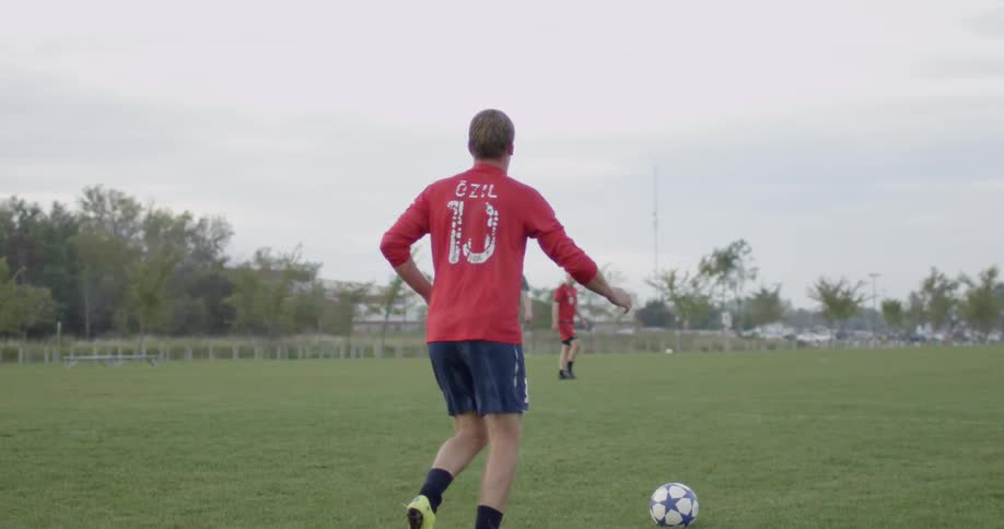 A player runs up and kicks the soccer ball