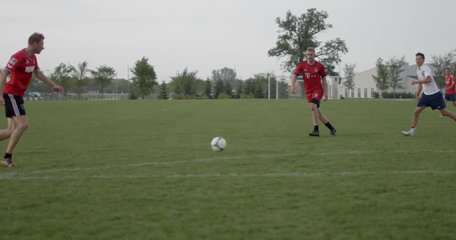 A group of men playing soccer outside on a field