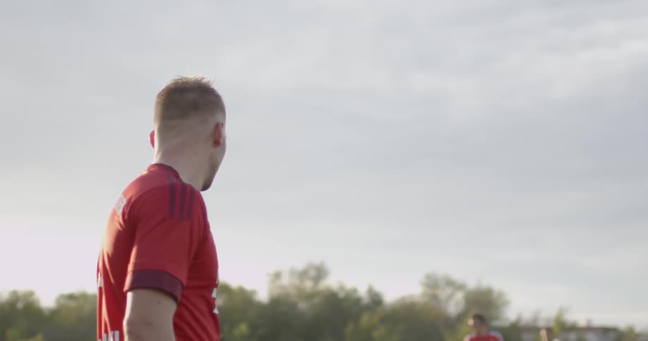 A man outside on a field watching around and waiting for soccer to begin