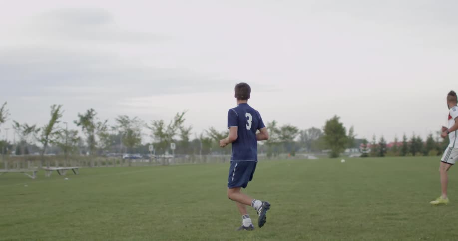 Soccer players run down a field