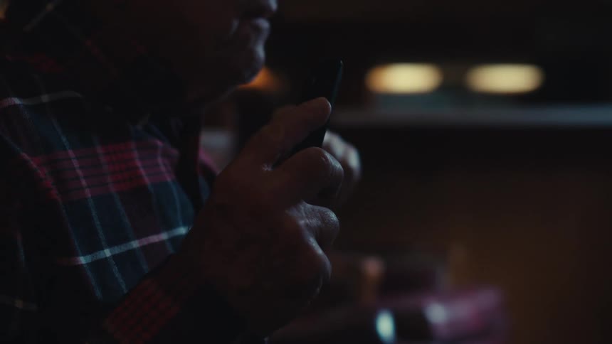A man is holding a remote control while watching television