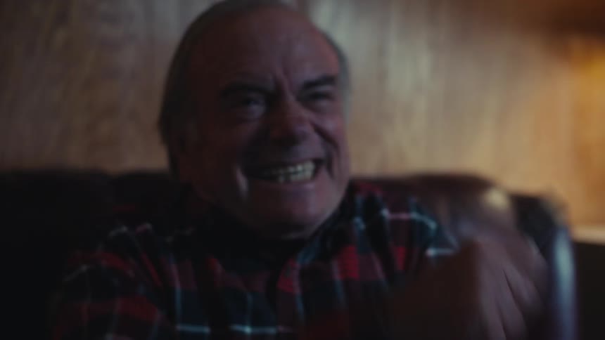 A man jumps in his seat and cheers at the television