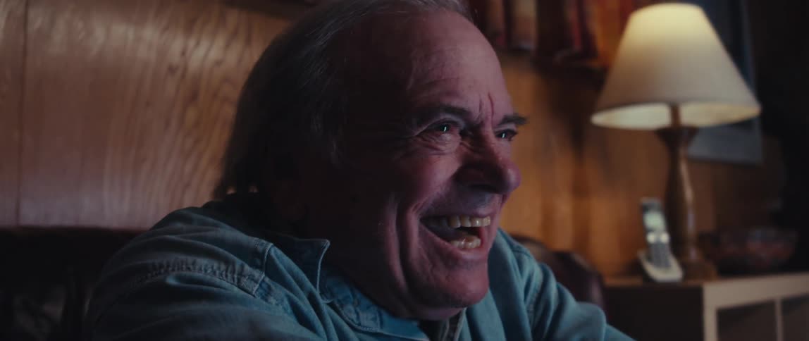 A man laughs as he watches television
