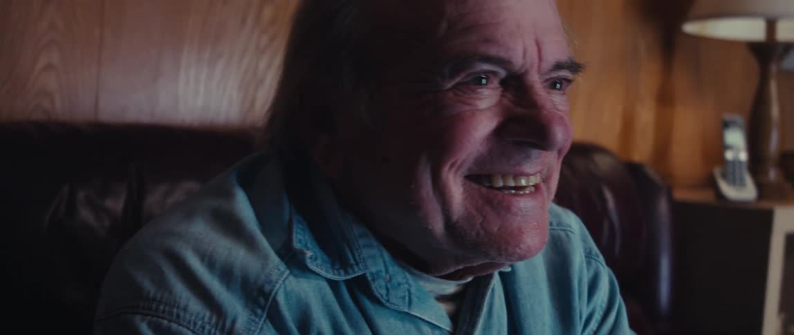 Elderly man sitting playing video games and having fun