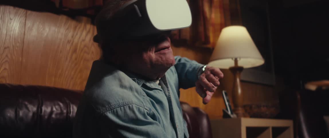 Elderly man sitting very happy while using a virtual reality headset
