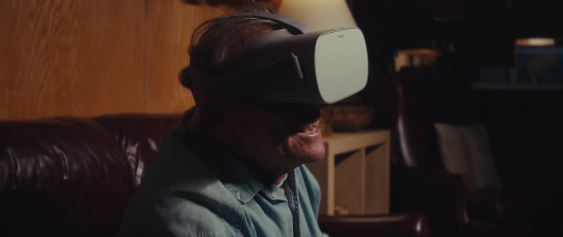 Elderly man having fun using virtual reality glasses while sitting in a living room