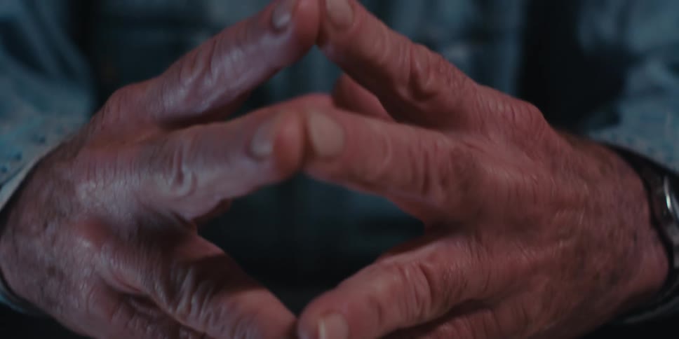 A man is touching clasping his hands together