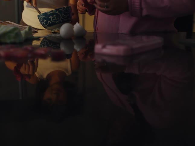 Two people are mixing food in a bowl