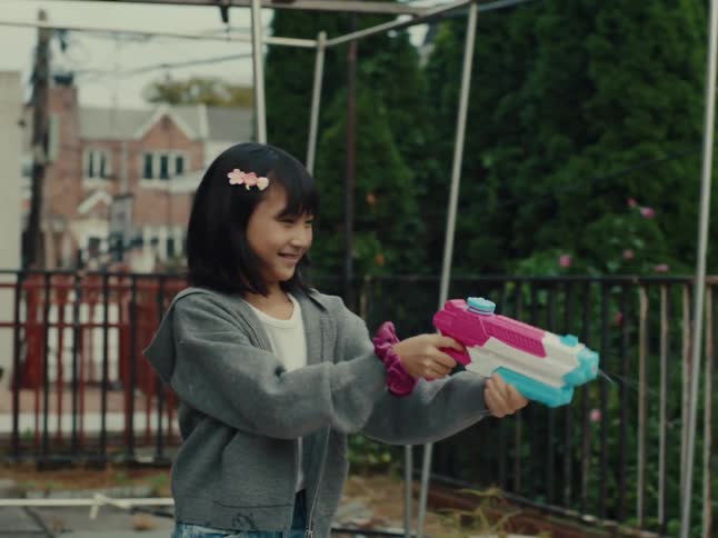 Two girls shoot water guns at each other
