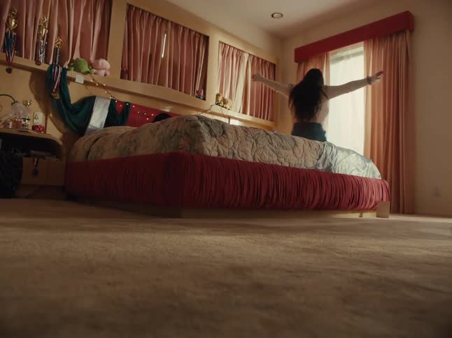 Girl and a teenager running around the room and throwing themselves on the bed