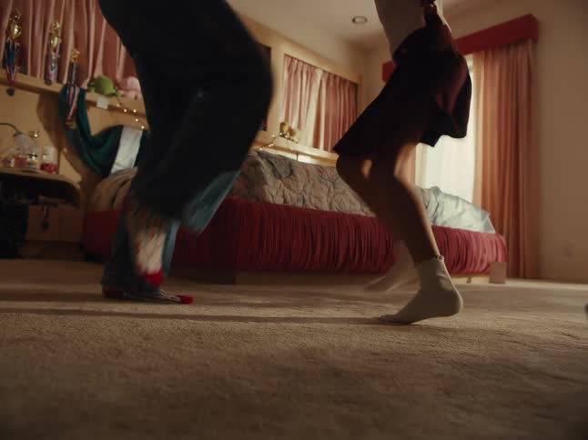 Legs of an adult person with a child playing together in a room