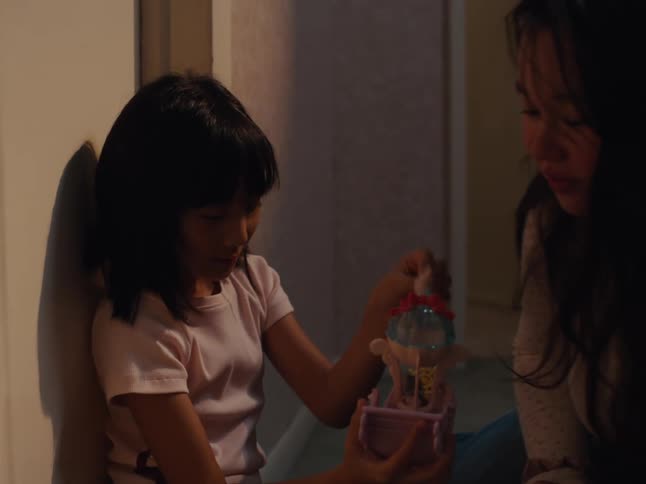 Woman and a girl sitting playing with toys