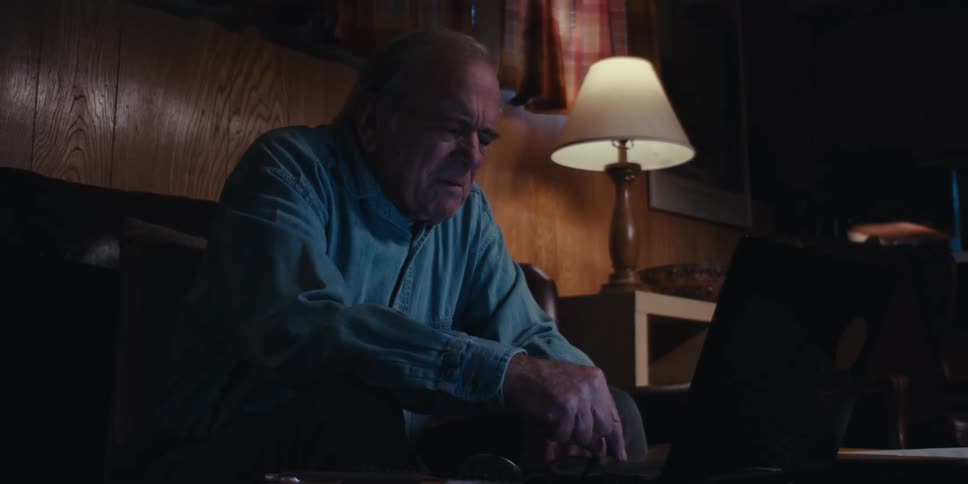 A clip of an elderly man operating a laptop indoor
