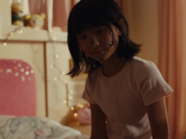 Little girl sticking stickers on her older sisters face