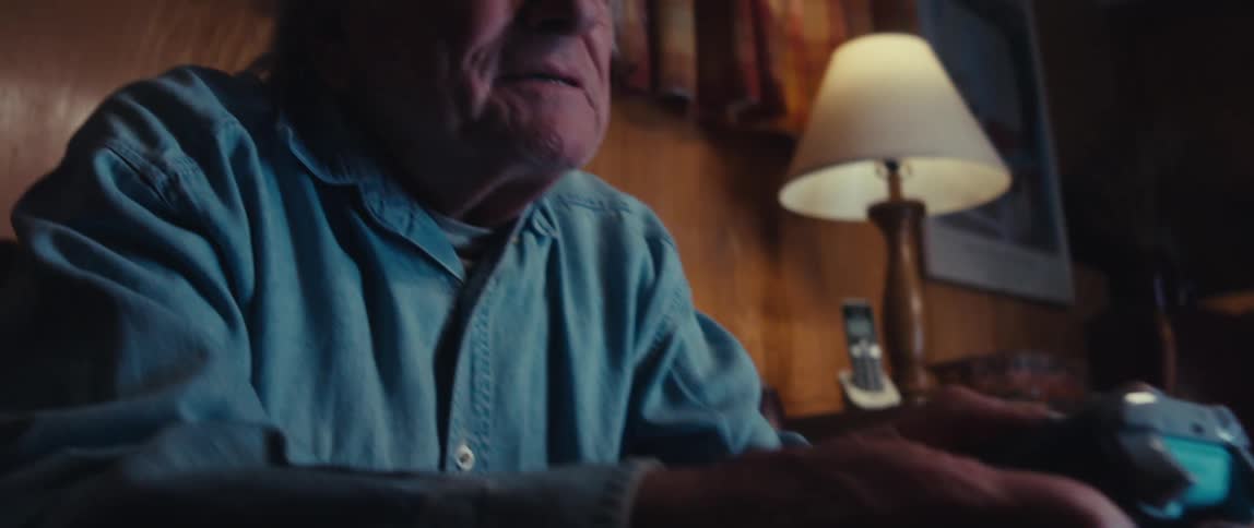 Elderly man happily cheering while playing video games