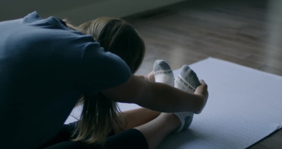 A woman is doing yoga stretching to her feet