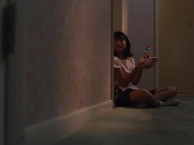 Girl sitting in a hallway playing with a toy