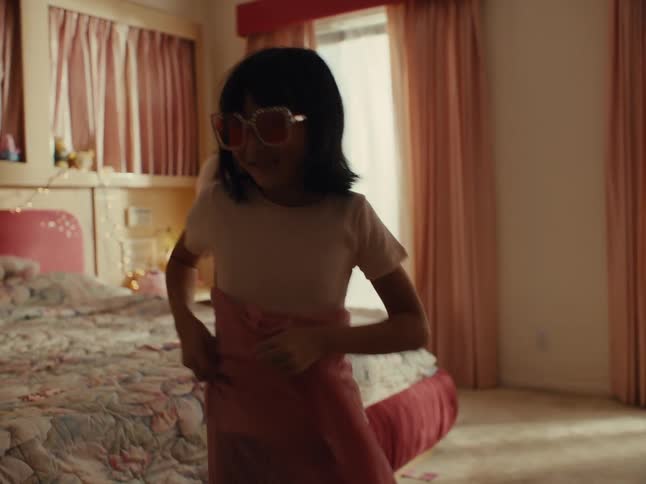 A girl dancing around playing in her bedroom
