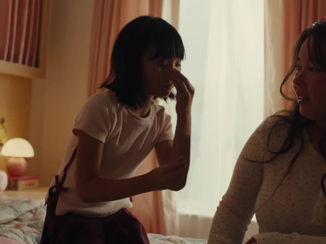 Teenager playing with a child on the bed in a bedroom