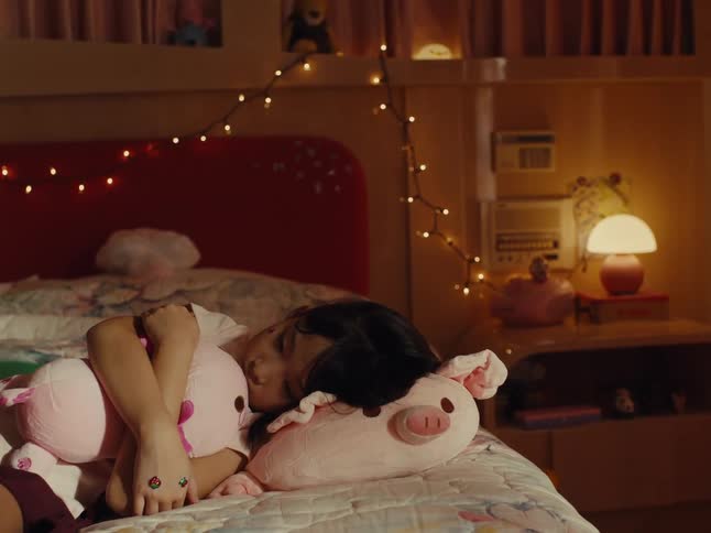 Mother comforts her daughter while the girl lies on a stuffed pig and cuddles another