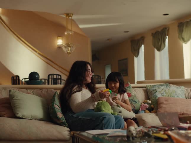 Teenage boy and little girl sitting in living room interacting with toys