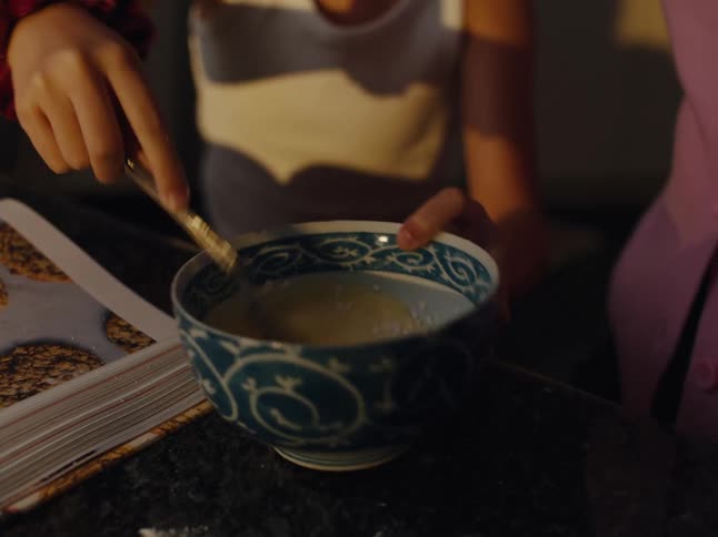 A child is mixing eggs in a bowl