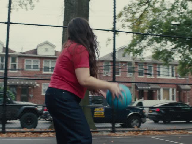 Little girl with a teenage girl playing basketball on an outdoor court