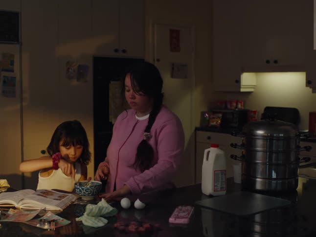 Mother and daughter in the kitchen with a recipe book cooking together
