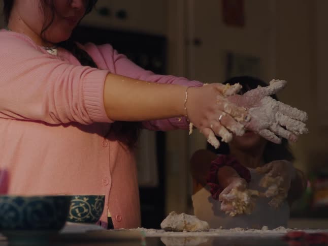 A clip of two females molding on a table