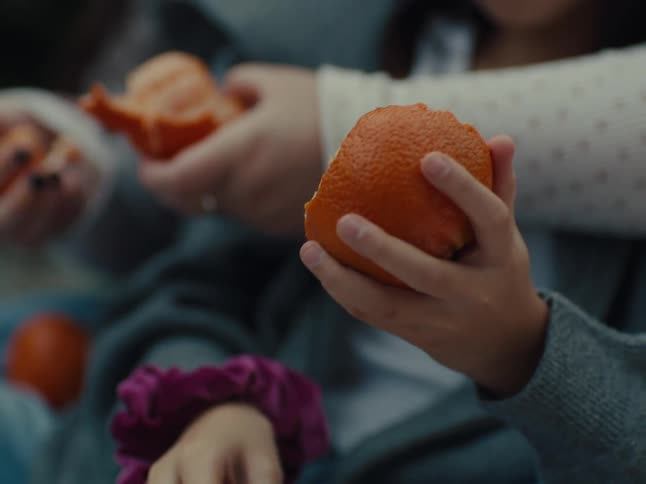 Children are peeling oranges