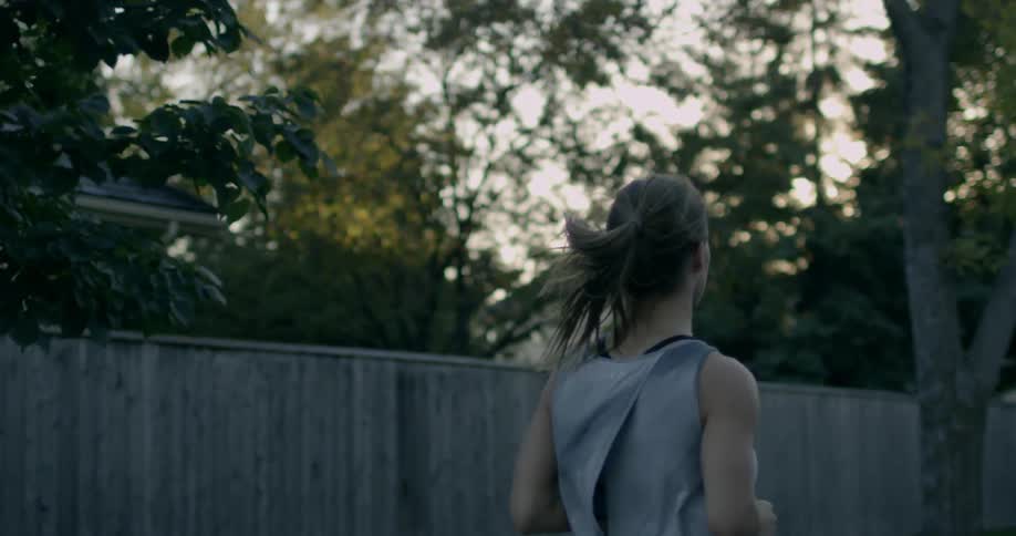 A woman is jogging through her neighborhood