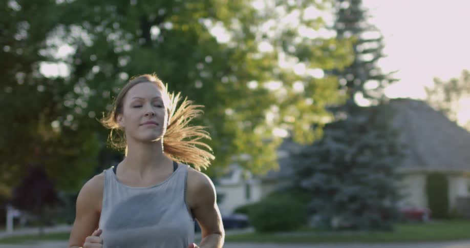 A woman is being filmed from the front while jogging