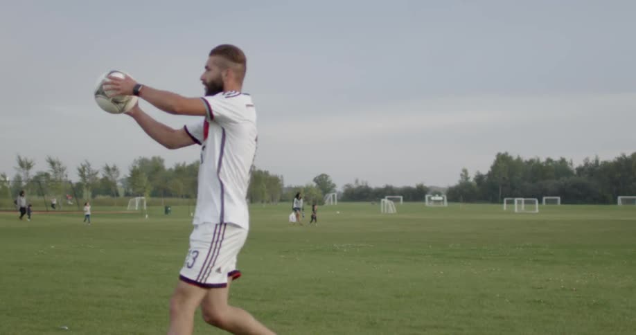 A soccer player throws the ball in