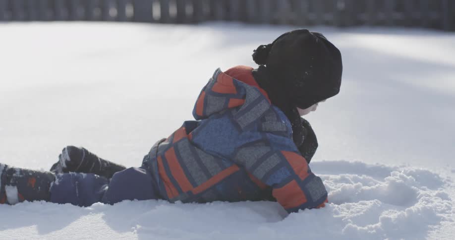 A little kid is playing in the snow